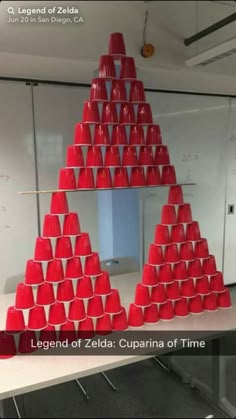 red cups stacked on top of each other in the shape of a pyramid, with caption legend of zeida cuppaina of time