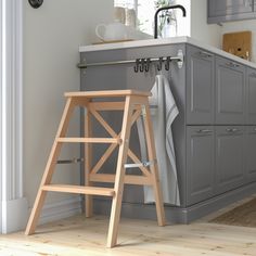 a wooden step stool sitting in the middle of a kitchen