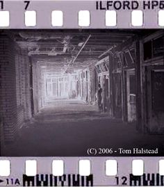 an old film strip with the image of a hallway in black and white