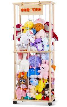 a wooden cage filled with lots of stuffed animals and toys on top of each other