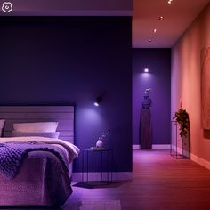 a bedroom with purple lighting and a large bed in the middle, along with a painting on the wall