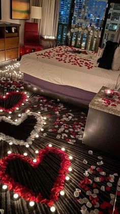 a bedroom decorated for valentine's day with candles in the shape of a heart