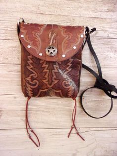 Crafted with a blend of rugged charm and western style, these one-of-a-kind Small Leather Crossbody Purses are the epitome of cowgirl chic. Handcrafted from authentic cowboy boots, each purse exudes a sense of unique style that is perfect for those who embrace country fashion. The western detailing adds a touch of flair reminiscent of rodeo culture, making it a must-have accessory for any modern cowgirl. Whether you're hitting the town or attending a western-themed event, these purses effortlessly blend into your wardrobe, elevating your outfit with a dash of western chic. Embrace your inner cowgirl and make a bold statement with these stylish and versatile Crossbody Purses that are bound to turn heads wherever you go.  Small Cowboy Boot Purse Handmade from 1-1/2 Boots No two alike. Wester Western Embellishments, Boot Purse, Cowboy Boot Purse, Hipster Purse, Hippie Cowgirl, Custom Cowboy Boots, Western Bag, Modern Cowgirl, Western Purses