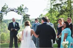 a man in a suit and tie standing next to a woman at a wedding ceremony