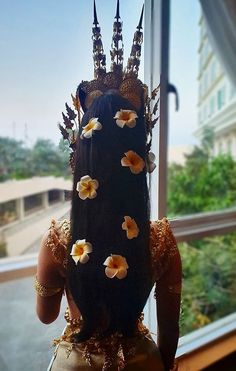 a vase with flowers on it sitting in front of a window