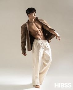 a shirtless man in white pants and jacket