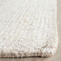 a white rug on top of a wooden floor