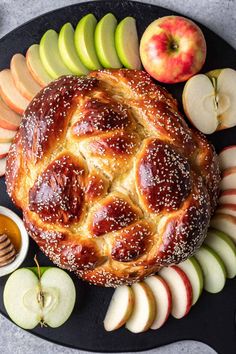 an apple pie on a platter with apples and honey