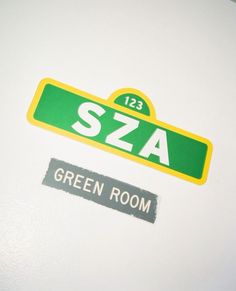 green and yellow stickers on the side of a white refrigerator door that says sza