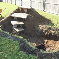 a pile of dirt sitting next to a wheelbarrow on top of a lush green field