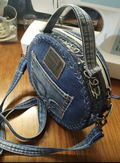 a denim purse sitting on top of a wooden table