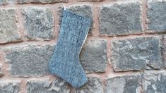 a blue sock hanging on a brick wall