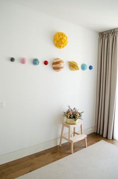 a room with a white wall and several planets on the wall