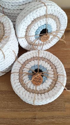 three white baskets with twine and tags on them sitting on a wooden table next to each other