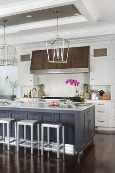 a large kitchen island with stools in front of it and an overhead light hanging from the ceiling