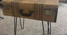 an old suitcase with hair pins sticking out of it sitting on the floor next to a chair