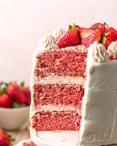 a strawberry cake with white frosting and strawberries on top