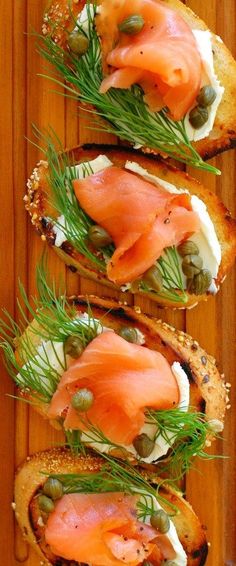 three slices of bread with salmon and capers on them