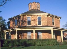 an old brick building with a clock tower on the top and two storyed windows