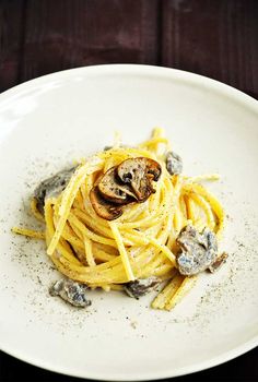 a white plate topped with pasta and mushrooms