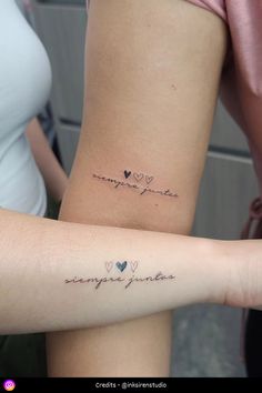 two people with tattoos on their arms and one has the word love written in cursive writing