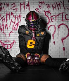 a football player sitting in front of a wall with graffiti