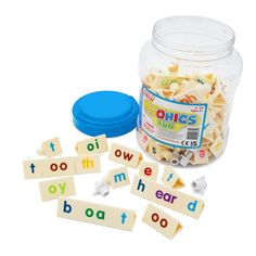 a jar filled with letters and words next to a blue plastic container full of magnets