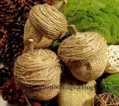 three stuffed animals made out of burlocks sitting on top of green moss and pine cones