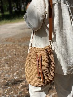 a woman carrying a straw purse on her shoulder