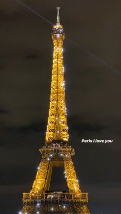 the eiffel tower lit up at night with lights on it's sides