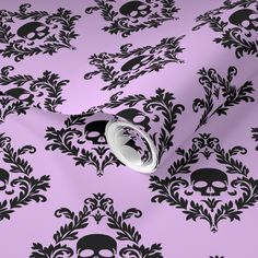 a pink and black wallpaper with skulls on it