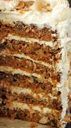 a large slice of carrot cake with white frosting and nuts on the top layer