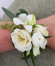 a bouquet of white flowers sitting on top of a person's arm