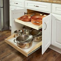 an open cabinet with pots and pans in it