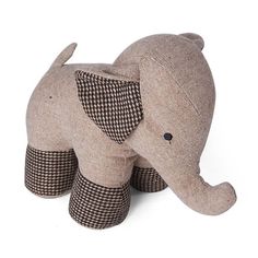 an elephant stuffed animal sitting on top of a white floor next to a black and white checkered pillow