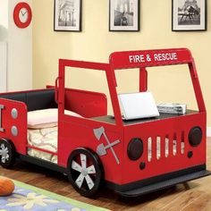 a red fire truck bed sitting on top of a wooden floor