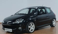 a small black car parked on top of a hard wood floor