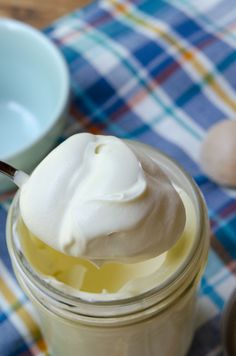 a jar filled with whipped cream sitting on top of a blue and white checkered table cloth