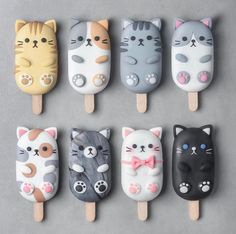 six pops with cats on them are lined up in the shape of an ice lolly