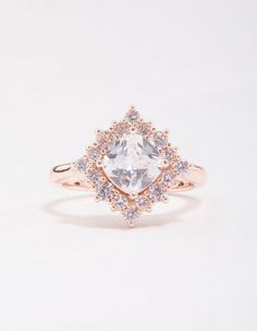 an engagement ring with a pear shaped diamond surrounded by smaller diamonds