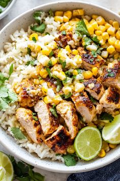 a white bowl filled with chicken, corn and cilantro on top of rice