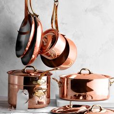 copper pots and pans are stacked on top of each other