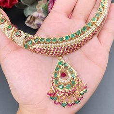 Featuring a traditional jadau necklace embellished with fine quality rubies, emeralds and pearls. This handcrafted piece of luxury has been crafted in 22ct gold. The necklace weighs 32.14 GMs including 1.29 GMs of hanging ruby emerald beads. The earrings weigh 22.87 GMs including3.4 GMs of ruby emerald beads. The intricate detailing perfectly complements traditional Indian attire, designed to be admired for generations to come. It's an exquisite representation of Indian culture and heritage. Traditional Round Emerald Necklace, Heavy Emerald Necklaces For Gifts, Kundan Emerald Necklace In Temple Jewelry Style, Emerald Kundan Temple Jewelry Necklace, Traditional Hand Set Yellow Gold Emerald Necklace, Traditional Green Emerald Necklace In 22k Gold, Traditional Gold Emerald Necklaces, Traditional Hand Set Emerald Necklace, Traditional Emerald Meenakari Necklace