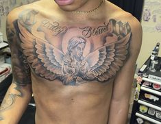 a man with an angel tattoo on his chest