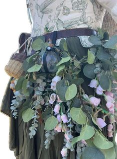 a close up of a person wearing a skirt with flowers and leaves on the bottom