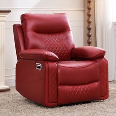 a red recliner chair sitting on top of a rug