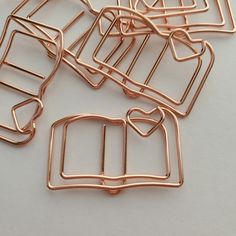 several pieces of metal wire sitting on top of a white surface with one piece cut in half