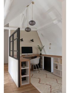 an attic office with white walls and wooden floors