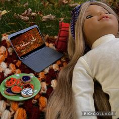 a doll laying on a blanket next to a laptop