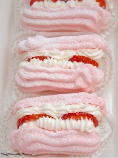 three desserts with strawberries and whipped cream on them